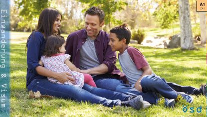 Eine Familie sitzt im Park und verbringt Zeit miteinander.